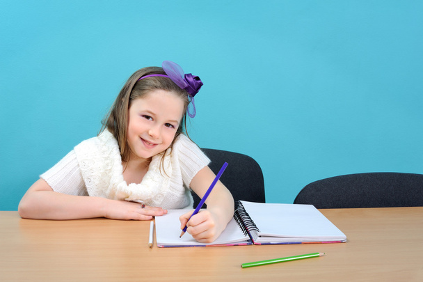 Feliz niña haciendo su trabajo escolar
 - Foto, Imagen