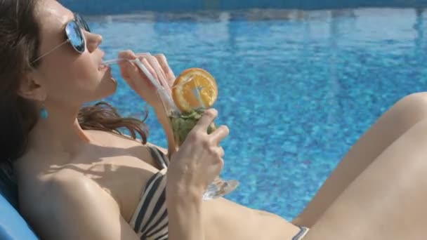 Sexy woman enjoys cocktail, summer beach. Suntanning near water - Filmati, video