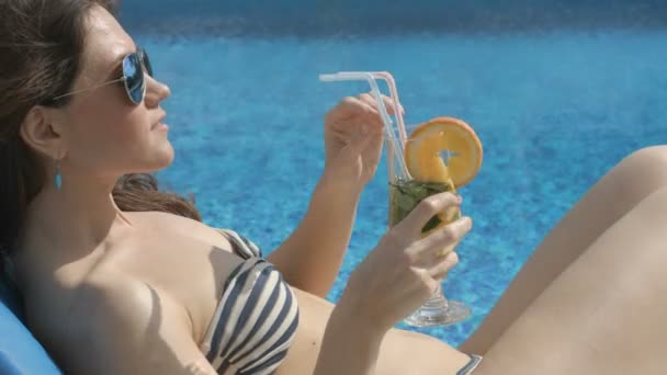 Hot chick drinking cocktail near swimming pool, smiling, teasing - Filmagem, Vídeo