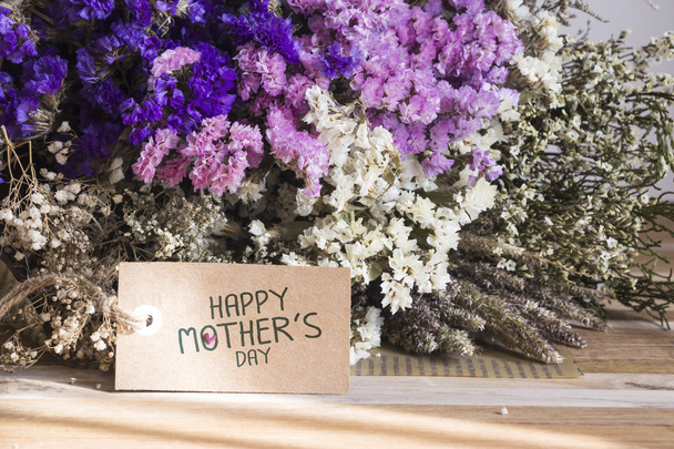 Букет сушеных цветов с открыткой на день матери на деревянном счете
 - Фото, изображение