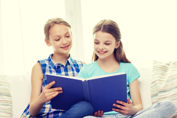 two happy girls reading book at home - Foto, Bild