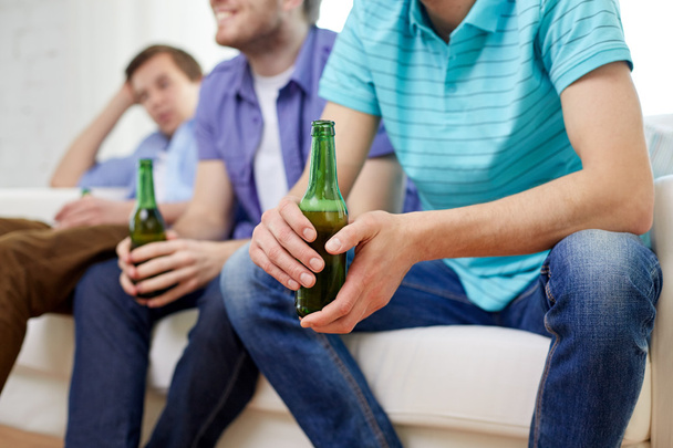 happy male friends drinking beer at home - Фото, зображення