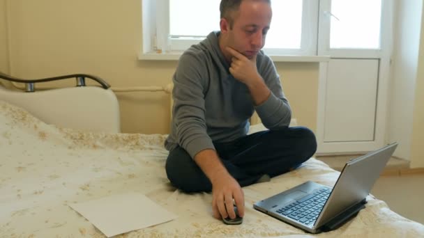 Mann konzentriert sich auf Arbeit oder soziale Medien auf seinem Laptop - Filmmaterial, Video