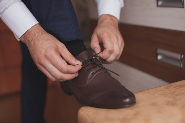 A man  to tie shoelaces - Φωτογραφία, εικόνα