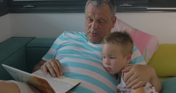 Nagyapja használ a laptop otthon és gyermek - Felvétel, videó
