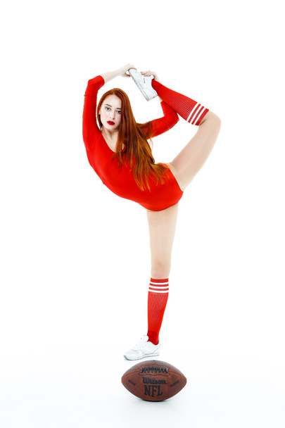 Pretty red- haired woman with football - Zdjęcie, obraz
