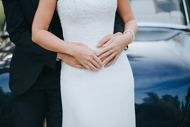 Groom hugging bride in white dress - Foto, imagen