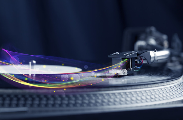 Turntable playing vinyl with glowing abstract lines - Fotografie, Obrázek
