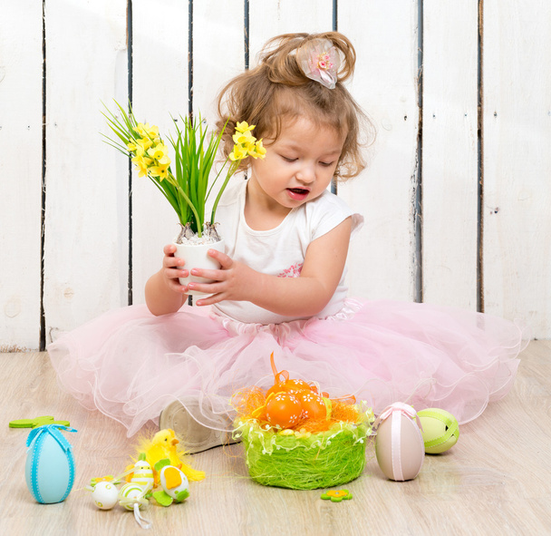 cute little girl sitting on the floor with flower pot in hands - Fotografie, Obrázek