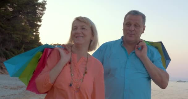Ältere Paare entspannen sich nach dem Einkauf bei einem Spaziergang am Meer - Filmmaterial, Video