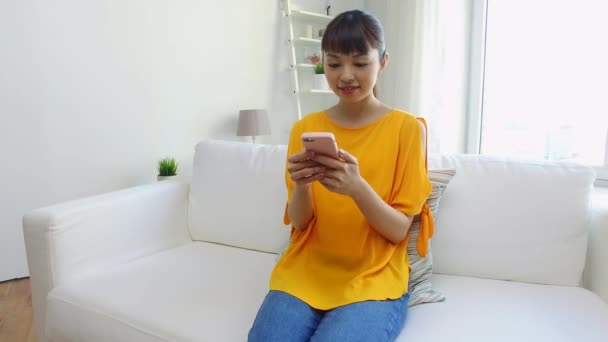 happy asian woman with smartphone at home - 映像、動画