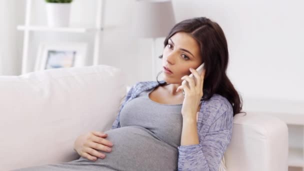 sad pregnant woman calling on smartphone at home - Video, Çekim