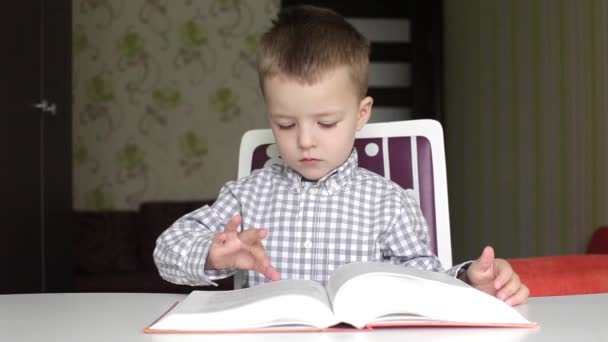 Boy turning the pages of big book - Footage, Video