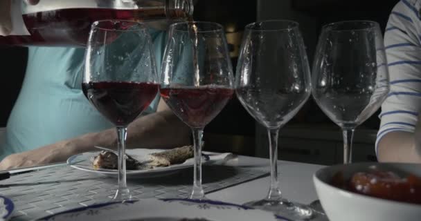 Man pouring red wine in four glasses - Footage, Video