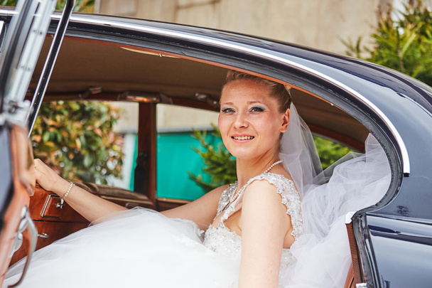 beautiful blond bride posing inside car - Foto, Bild
