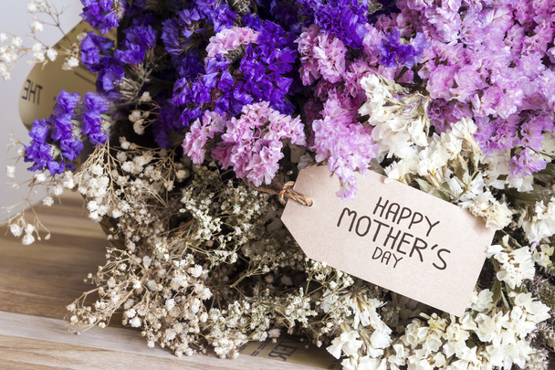 Μπουκέτο από αποξηραμένα λουλούδια με κάρτα για τη γιορτή μητέρες στην καρτέλα ξύλινα - Φωτογραφία, εικόνα