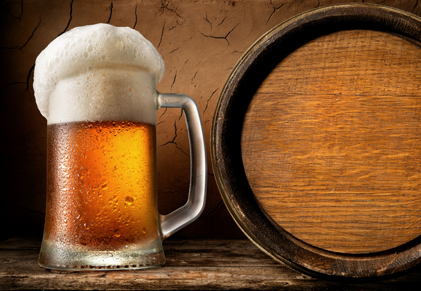 Frothy beer and barrel - Φωτογραφία, εικόνα