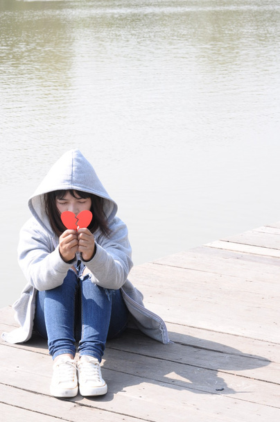 Грустная девочка-подросток в депрессии, сидя на полу моста
 - Фото, изображение