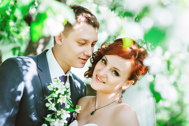 Счастливые молодой муж и жена, в цветах, она смотрит в камеру
. - Фото, изображение