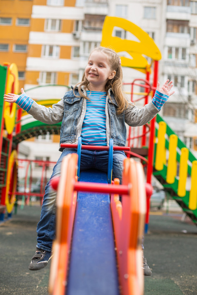 Girl swinging at the playground - Фото, изображение