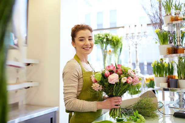 smiling florist woman making bunch at flower shop - Fotoğraf, Görsel
