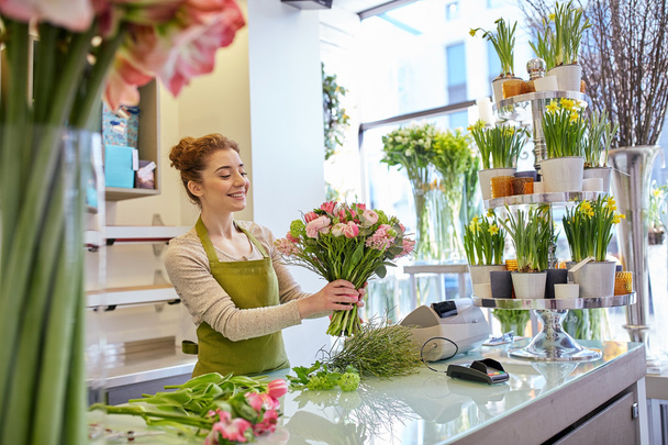 smiling florist woman making bunch at flower shop - Фото, зображення