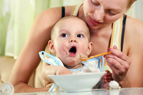 Mamma che alimenta il bambino con cucchiaio
 - Foto, immagini
