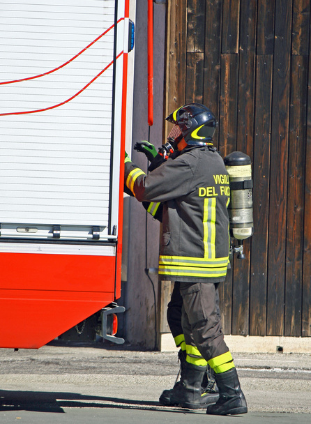 brandweerman met zuurstof cilinder en open de brandweerauto's - Foto, afbeelding