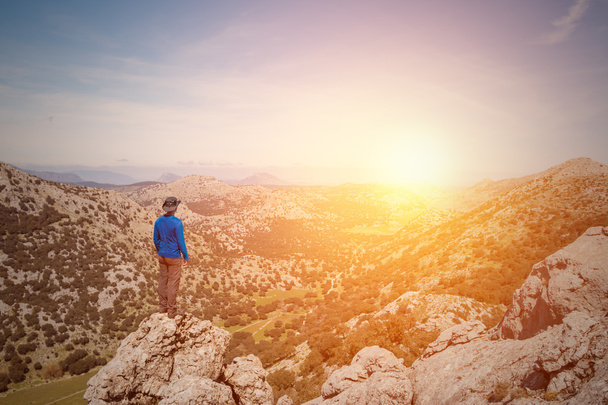 Чоловік мандрівник дивиться пейзаж на заході сонця
 - Фото, зображення