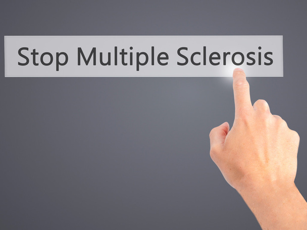 Detener la esclerosis múltiple - Mano presionando un botón en la espalda borrosa
 - Foto, Imagen