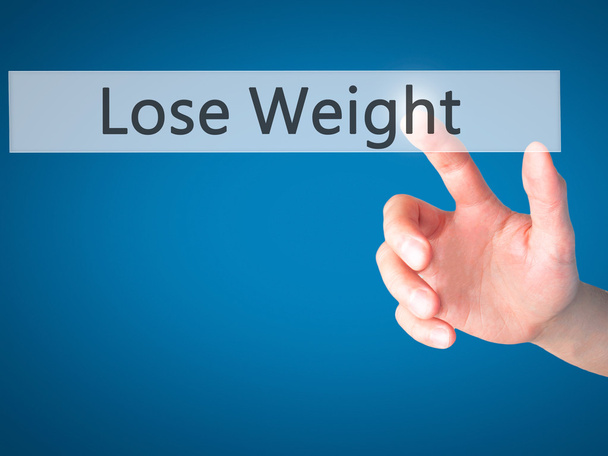 Perder peso - Mano presionando un botón sobre el cono de fondo borroso
 - Foto, imagen
