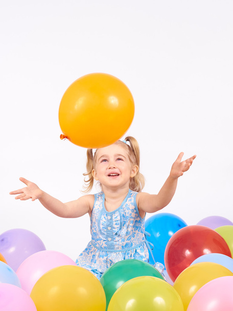 mała dziewczynka bawi się balonami. - Zdjęcie, obraz