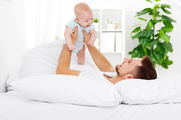 mutlu aile baba ve bebek yatakta - Fotoğraf, Görsel