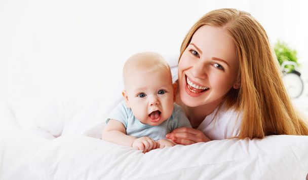 glückliche Familienmutter mit Baby im Bett - Foto, Bild