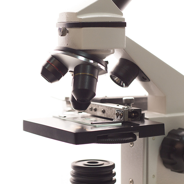Vecchio microscopio a luce su fondo bianco isolato vicino
 - Foto, immagini