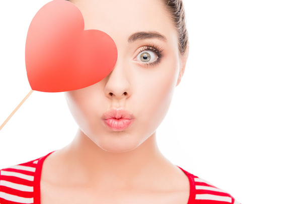 Funny woman holding paper heart near eyes and pouting - Foto, Imagen