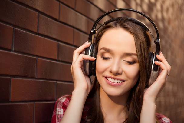 Close up portrait of young cheerful girl listening music with he - Zdjęcie, obraz