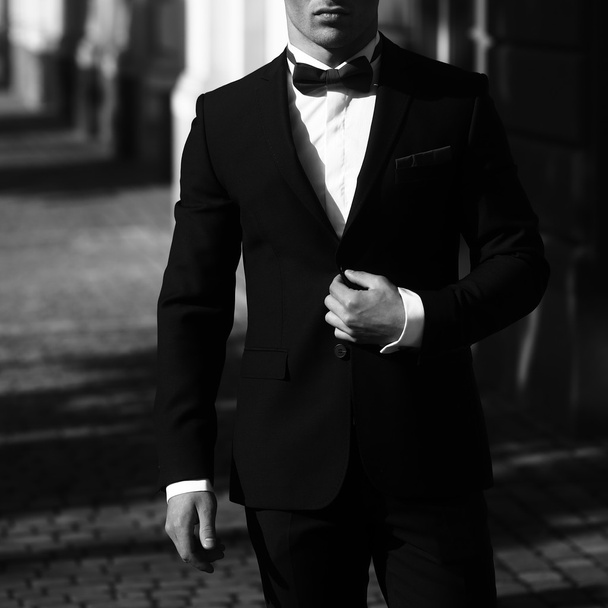 Elegant man unbuttons suit coat - Zdjęcie, obraz