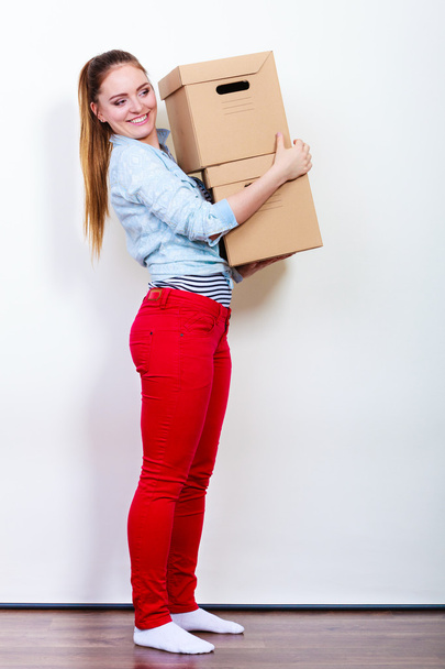 Happy woman moving into house carrying boxes. - Foto, immagini