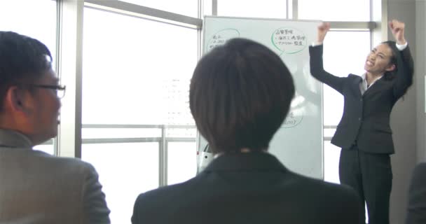 Japanese business women pumps up the team before a big sales meeting 4K - Кадри, відео