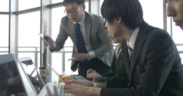 Gemotiveerde Japans werkplannen team maken samen gecontroleerd door de baas glijden schot - Video