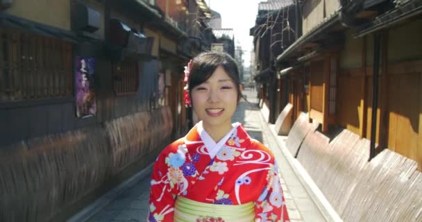 Krásná japonská dívka v kimonu úsměvy a procházky s fotoaparátem  - Záběry, video