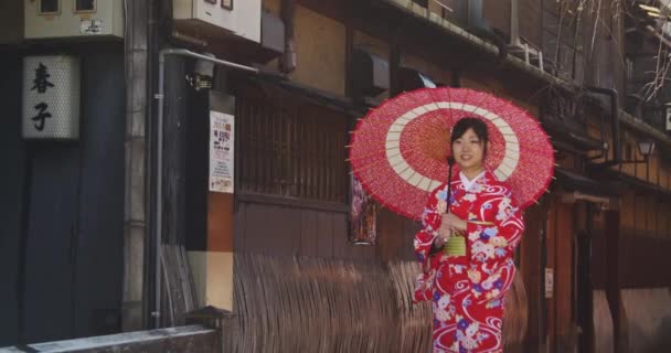 Όμορφο κορίτσι Ιαπωνικά κιμονό με paracel βόλτες μέσα από την οδό του Κιότο  - Πλάνα, βίντεο