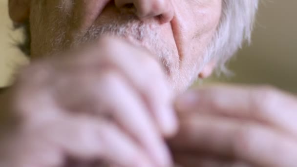 An aging senior takes out his hearing aid, checks it and put's it back in - Filmagem, Vídeo