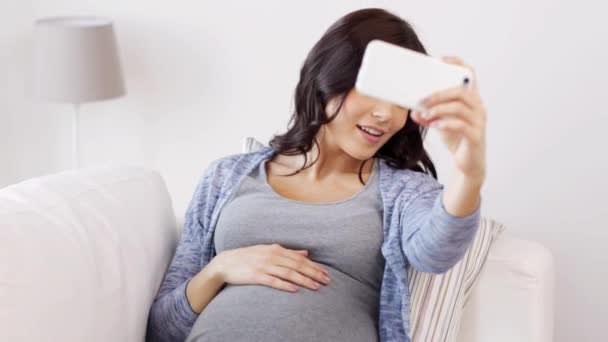 pregnant woman taking selfy by smartphone at home - 映像、動画