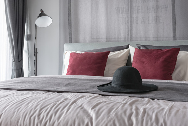 zwarte hoed op bed in moderne slaapkamer ontwerp  - Foto, afbeelding