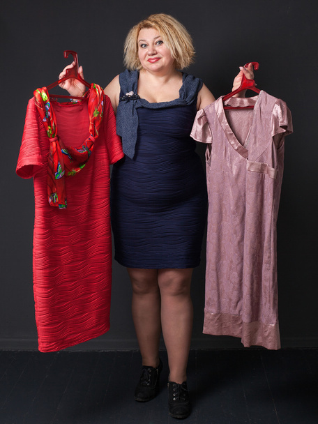 Mature blonde woman  choosing dress - Фото, изображение