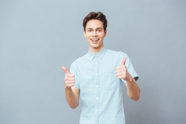 Happy casual man showing thumbs up - Fotoğraf, Görsel