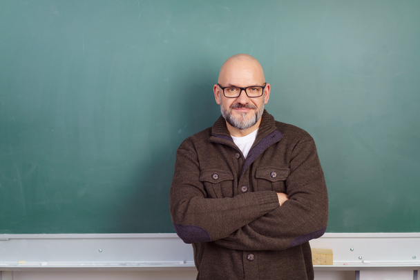 Confident male teacher in front of a chalkboard - Foto, afbeelding