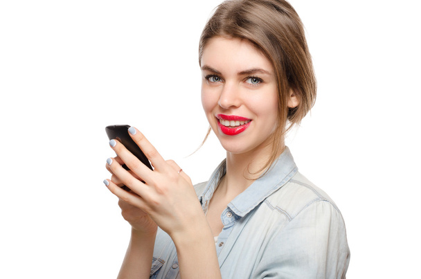 beautiful young woman chatting sms or serfing the internet by mobile phone, on a white background - Fotografie, Obrázek